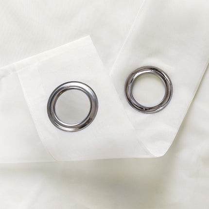 Doorschijnend vitrage gordijn met metalen ringen.