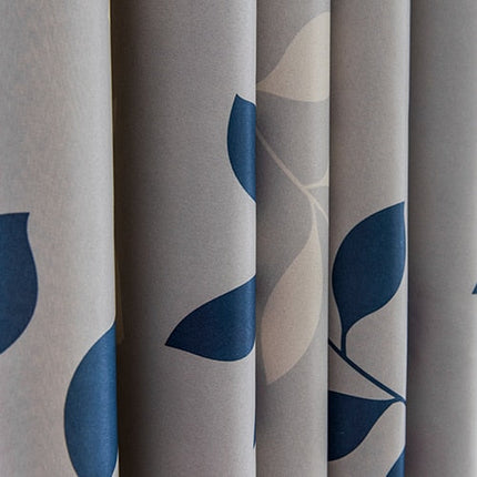 Grijs gordijn met blauw bladeren motief