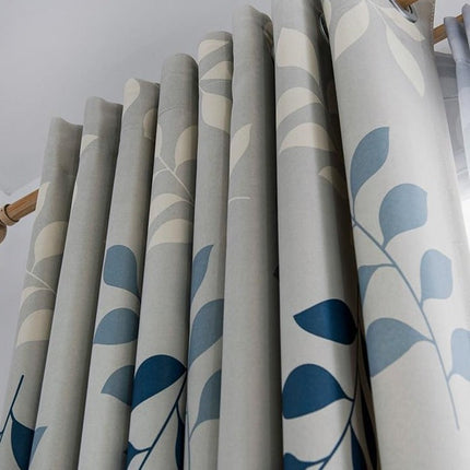 Grijs gordijn met blauw bladeren motief