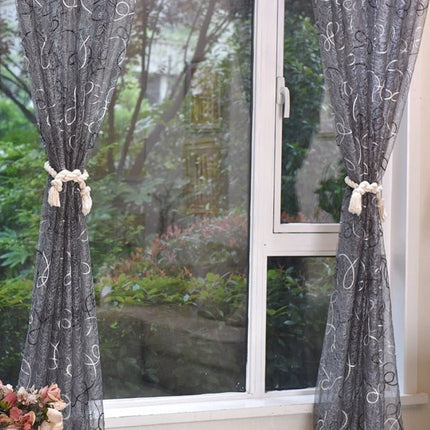 Grijze vitrage met geborduurd krulpatroon