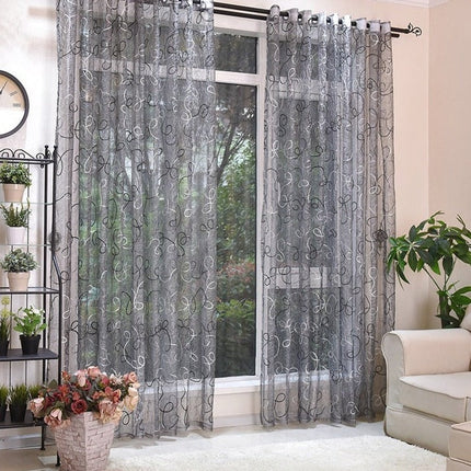 Grijze vitrage met geborduurd krulpatroon