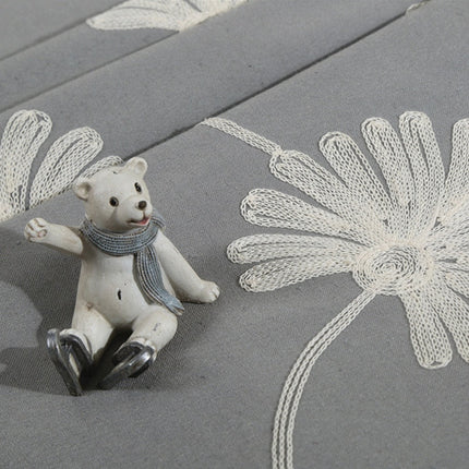 Grijs gordijn met geborduurde madeliefjes