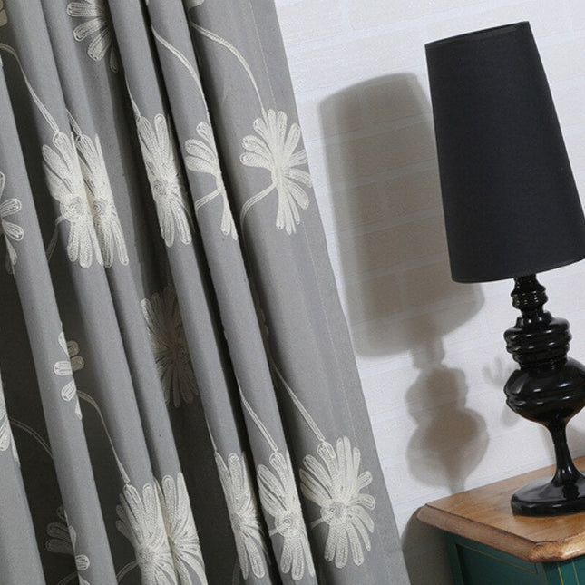 Grijs gordijn met geborduurde madeliefjes